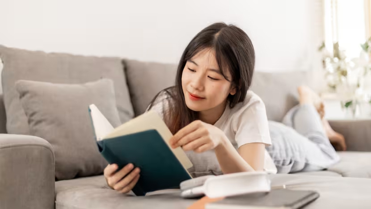 Ilustrasi seseorang meletakkan ponsel dan memilih untuk membaca buku atau berinteraksi sosial dengan tenang saat waktu puasa.