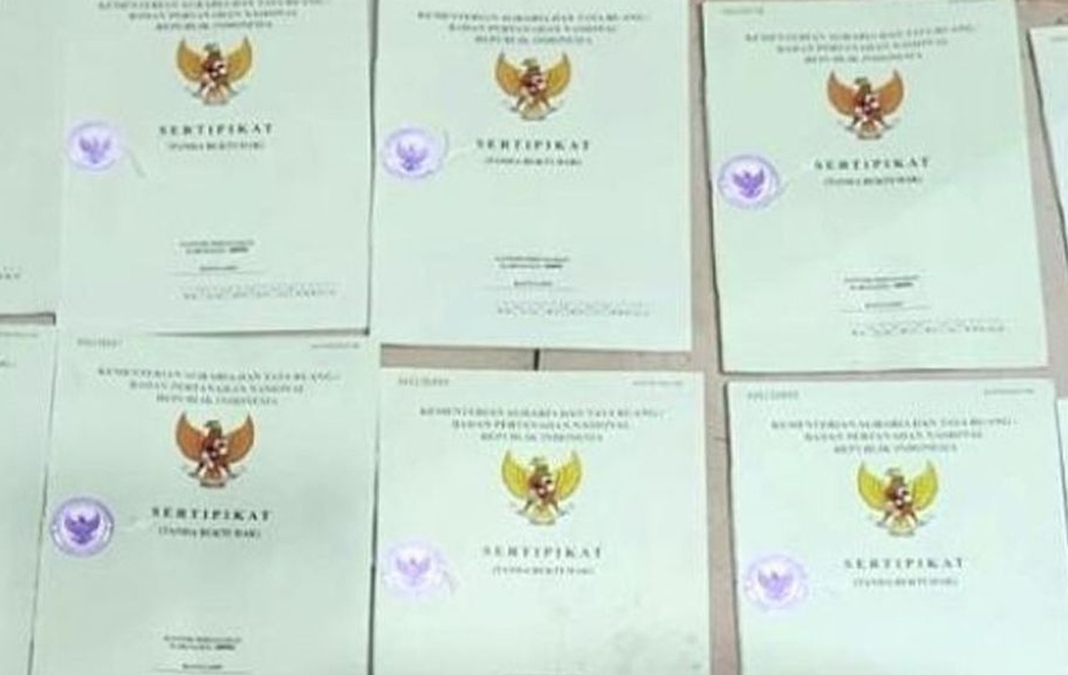 Petugas Kantor Pertanahan memeriksa dokumen sertifikat tanah.