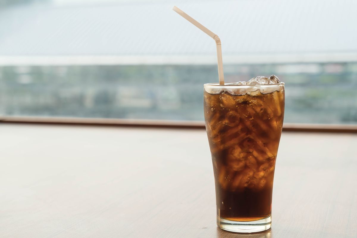 Ilustrasi minuman bersoda dingin dengan latar belakang yang menggambarkan risiko gangguan suasana hati atau depresi pada perempuan